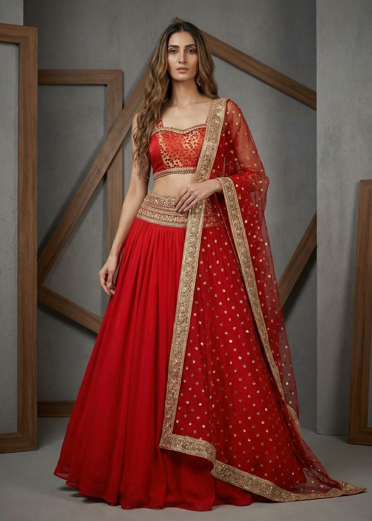 Woman wearing a red traditional outfit with gold embroidery in a minimalistic setting.