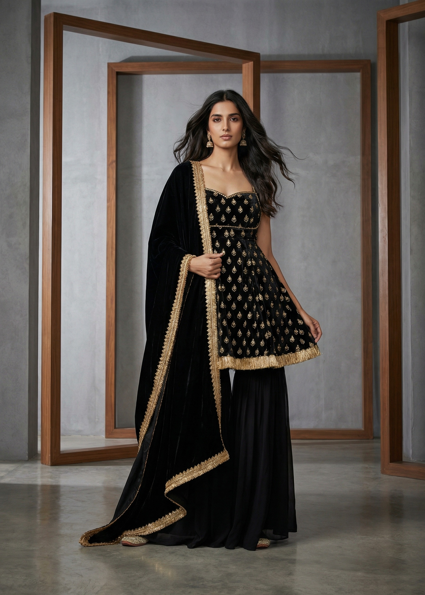 Woman in a black and gold traditional outfit standing in front of a mirror.