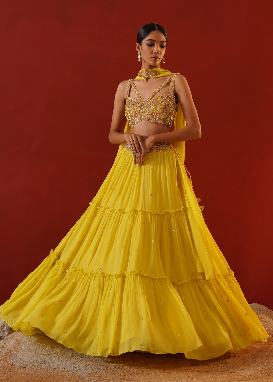 Woman wearing a yellow traditional outfit with a red background