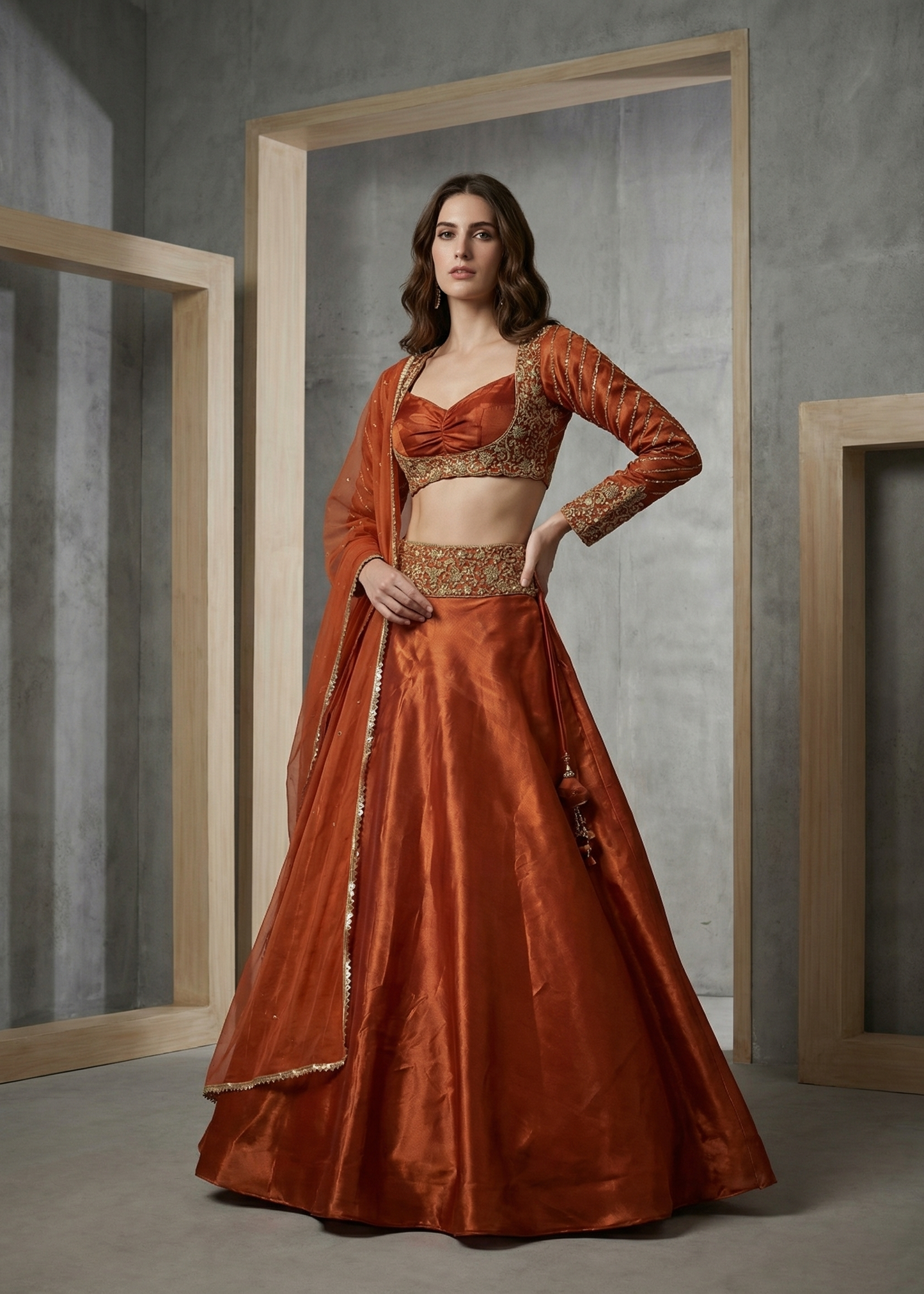 Woman in a rust-colored traditional outfit standing in a minimalistic room with wooden frames.