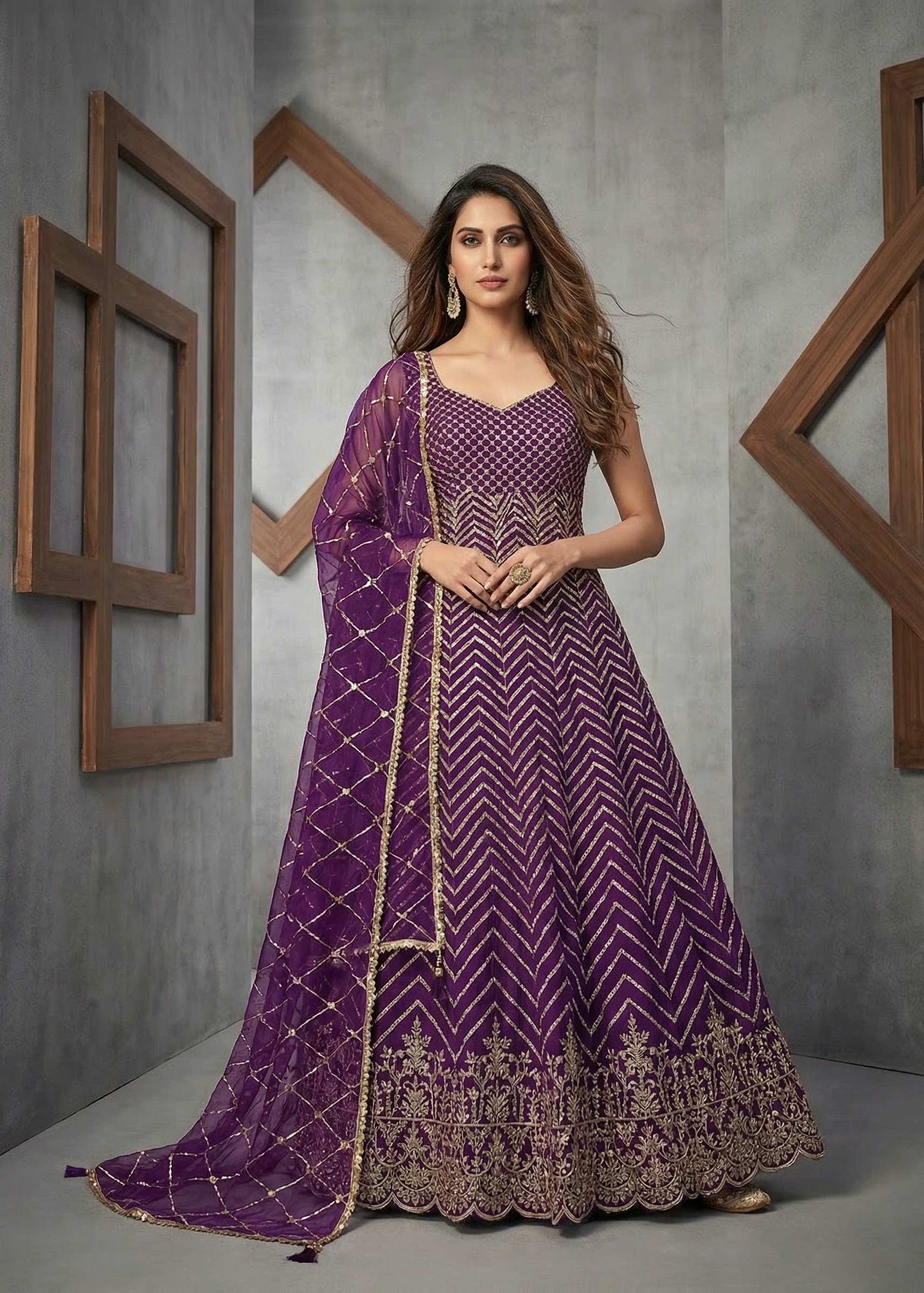 Woman wearing a purple embroidered traditional outfit against a gray background