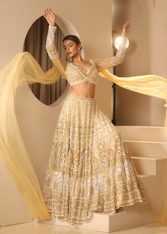 Woman in a sparkling gold dress with a long train in an elegant interior setting