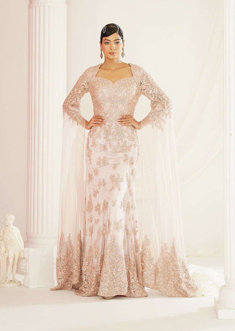 Woman in a floral evening gown standing in a classical setting with columns.
