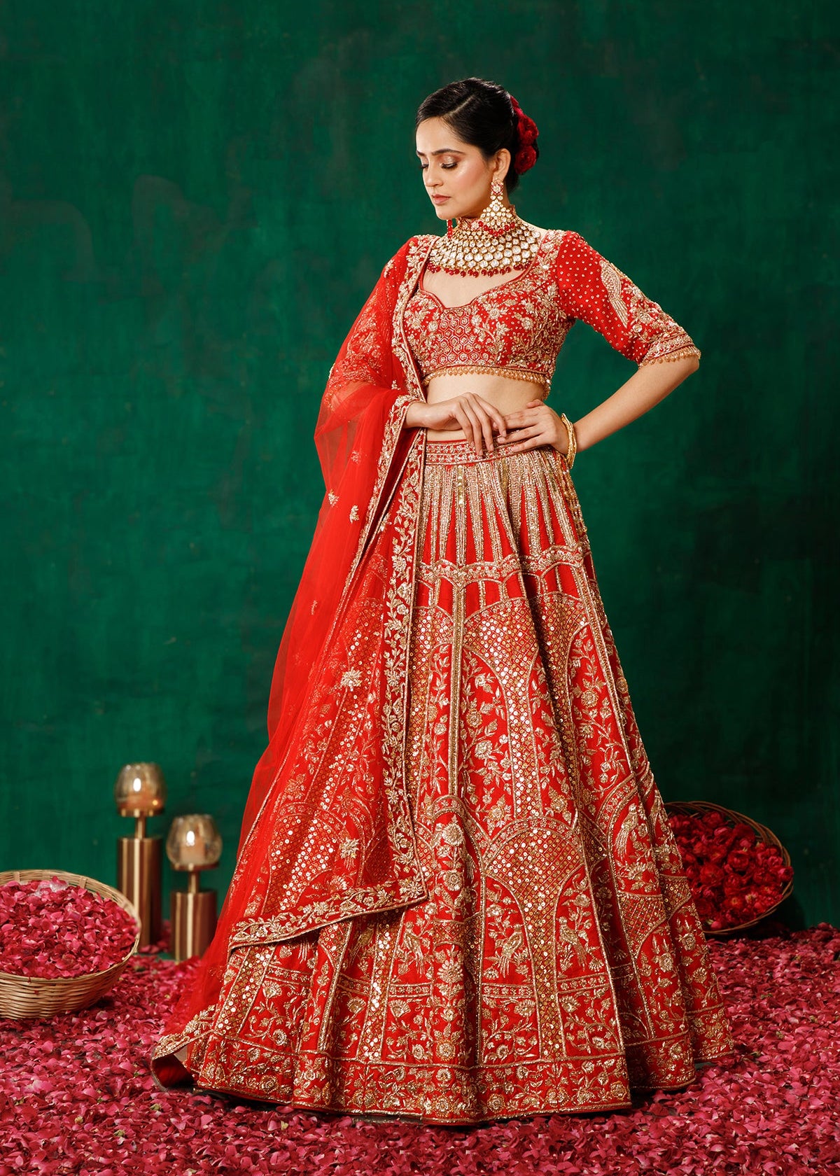 Woman in a red and gold embroidered traditional outfit on a green and red background