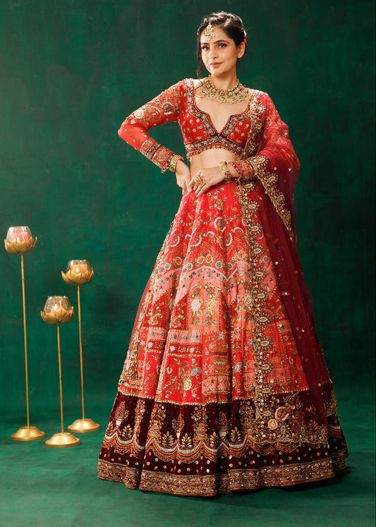 Woman in a red and gold traditional outfit with intricate designs on a green background
