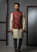 Man wearing a traditional kurta with a maroon vest against a gray background