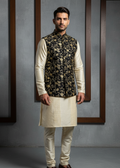 Man wearing a traditional kurta with a floral vest against a gray background