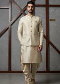 Man wearing a cream traditional kurta set against a gray wall with wooden crossbars.