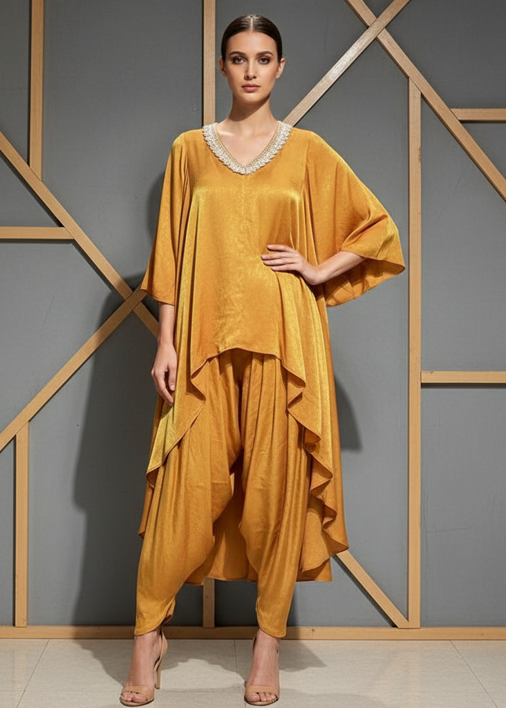 Woman wearing a mustard yellow outfit against a geometric-patterned wall.