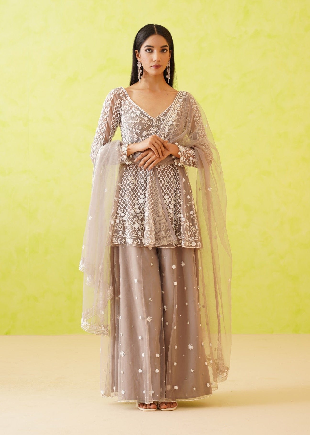 Woman wearing a traditional outfit with a light green background