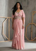 Woman wearing a pink saree with a gray background