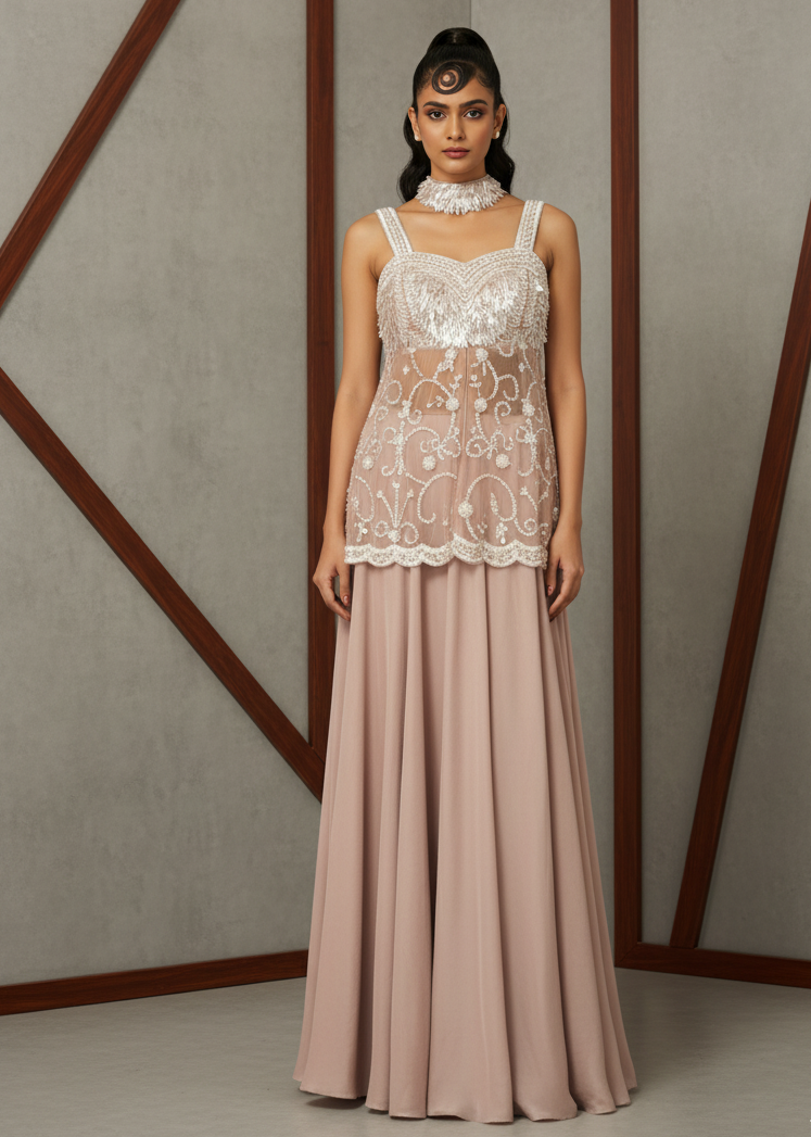 Woman wearing a lace top and long skirt against a geometric wall.