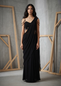 Woman wearing a black saree with a textured blouse against a gray background