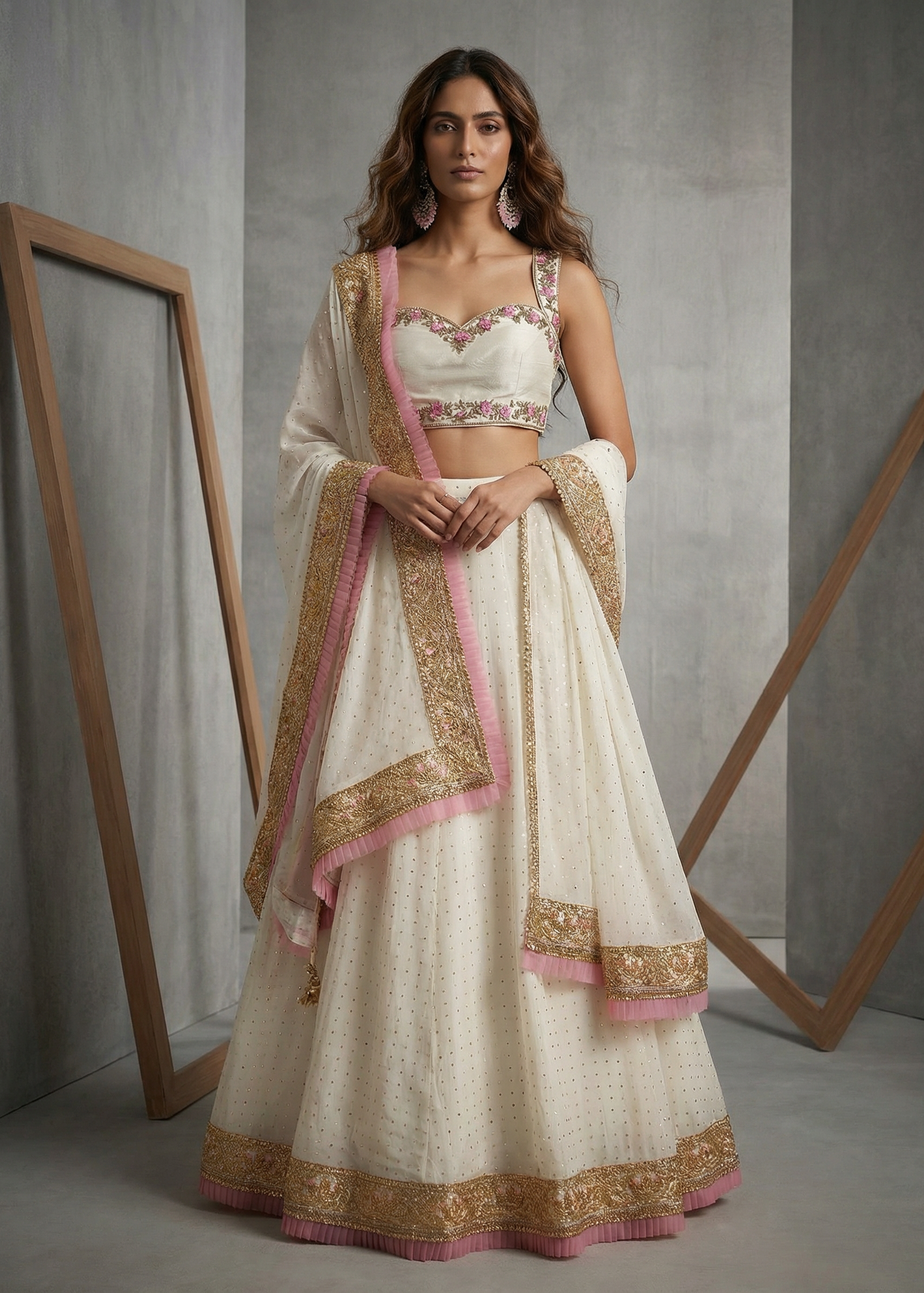 Woman wearing a traditional outfit with gold and pink details against a gray background