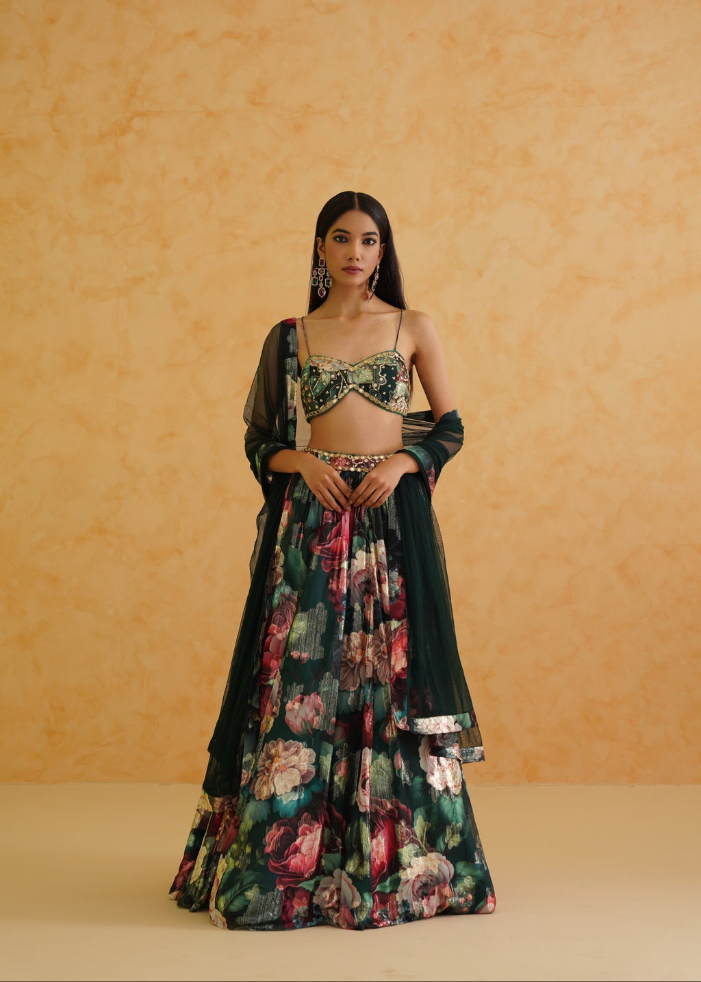 Woman wearing a floral and dark green traditional outfit against an orange background