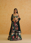 Woman wearing a floral and dark green traditional outfit against an orange background