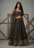 Woman wearing a black and gold traditional outfit with a gray background