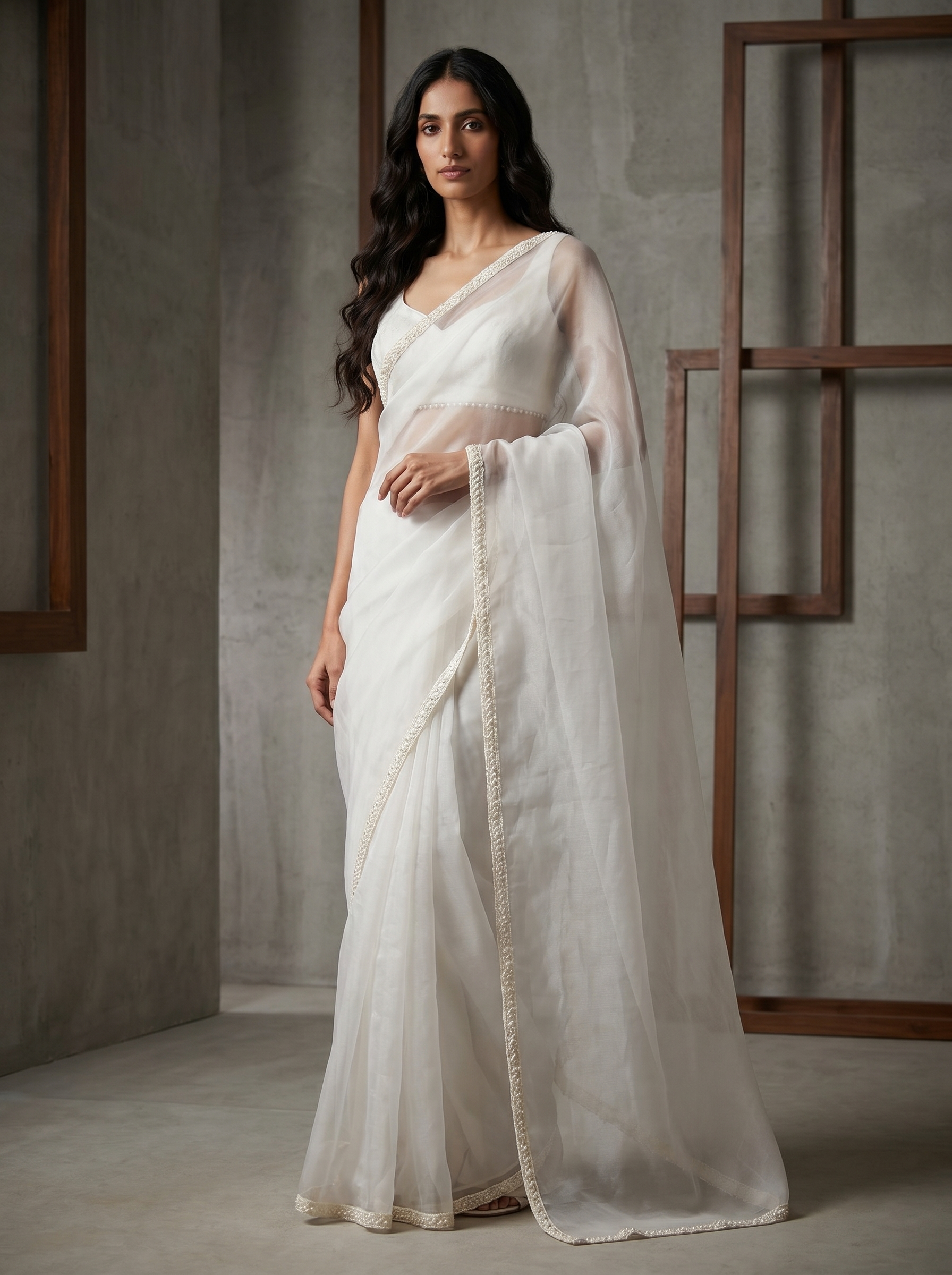 Woman wearing a white saree with a plain background