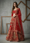 Woman wearing a red and gold embroidered traditional outfit against a gray concrete wall.