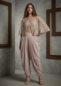 Woman wearing a floral cape over a matching outfit in a minimalistic setting
