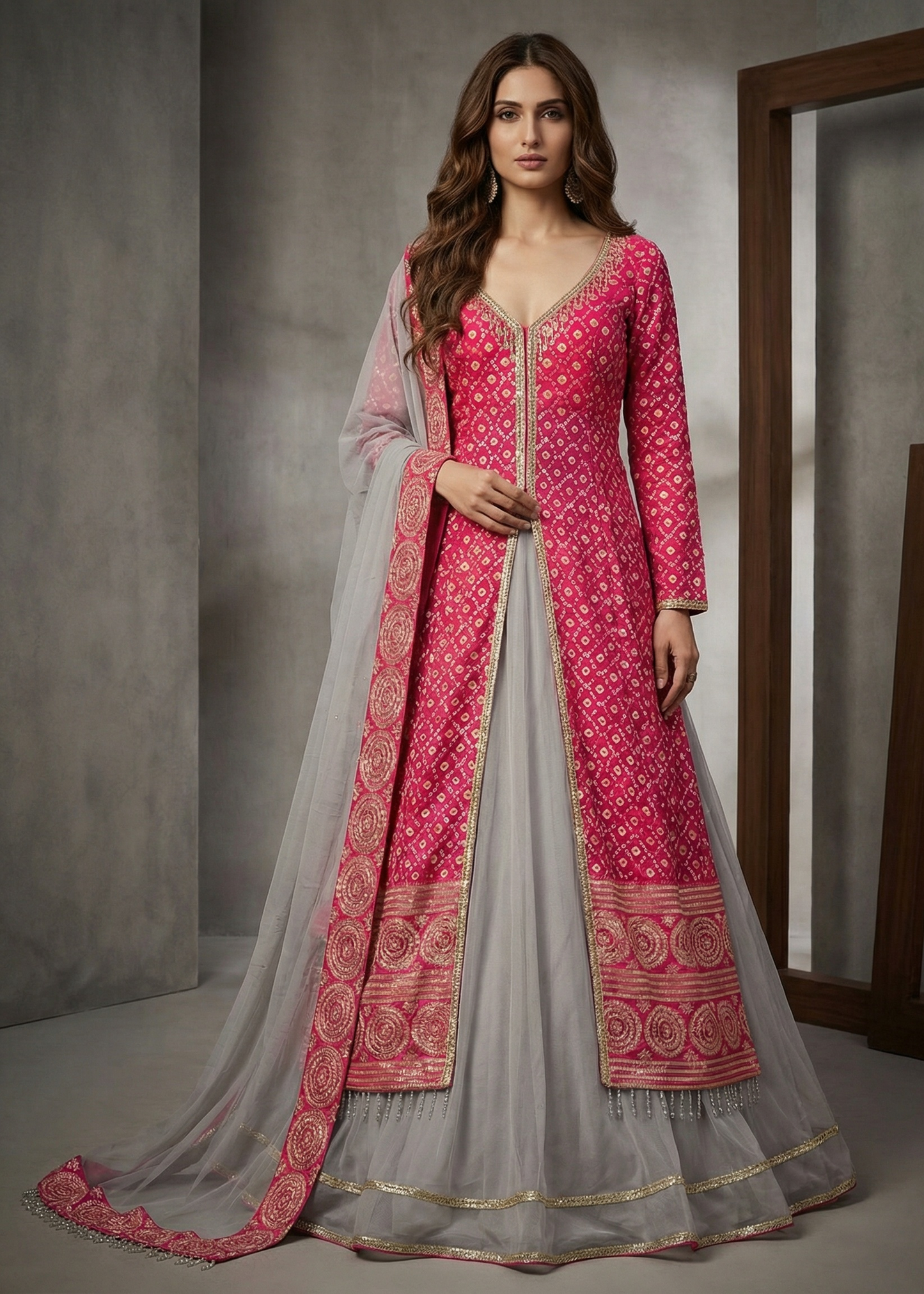 Woman wearing a pink and gray traditional outfit with intricate patterns.