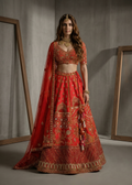 Woman in a red embroidered traditional outfit standing against a neutral background