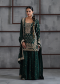 Woman wearing a traditional green and gold outfit against a gray background