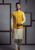Man wearing a yellow embroidered vest over a cream kurta with white pants against a gray background